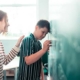 skoledreng læner sig op ad en tavle imens en kvindelig lærer opmuntrer ham